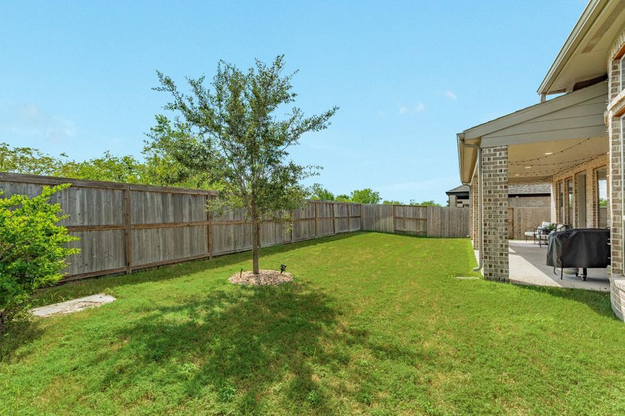 Beautiful backyard view featuring lush landscaping and a private outdoor area perfect for entertaining. Beautiful backyard view featuring lush landscaping and a private outdoor area perfect for entertaining.