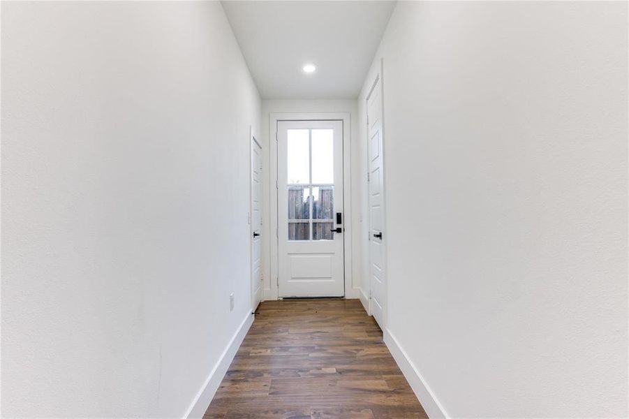 Doorway with dark hardwood / wood-style flooring