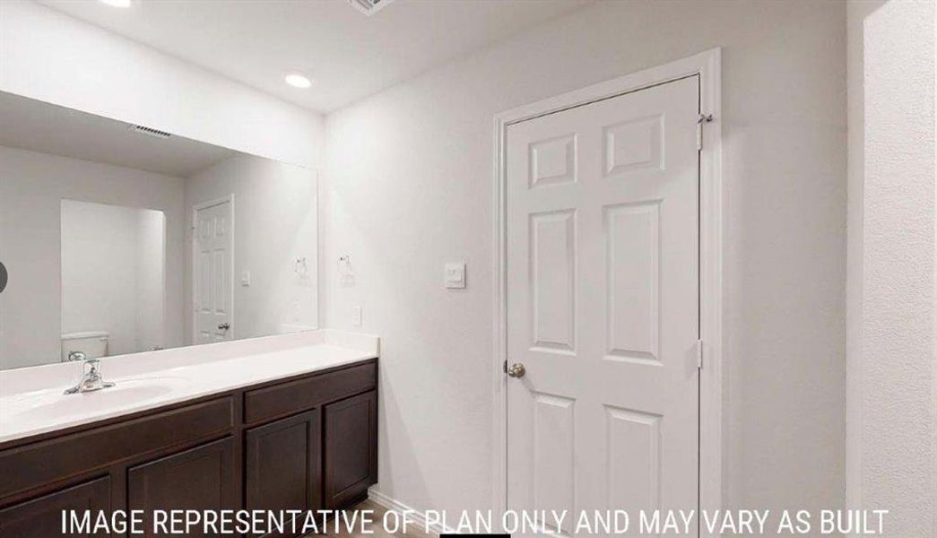 Bathroom vanity featuring a single basin sink, silver-tone faucet, and dark wood cabinetry Bathroom vanity featuring a single basin sink, silver-tone faucet, and dark wood cabinetry