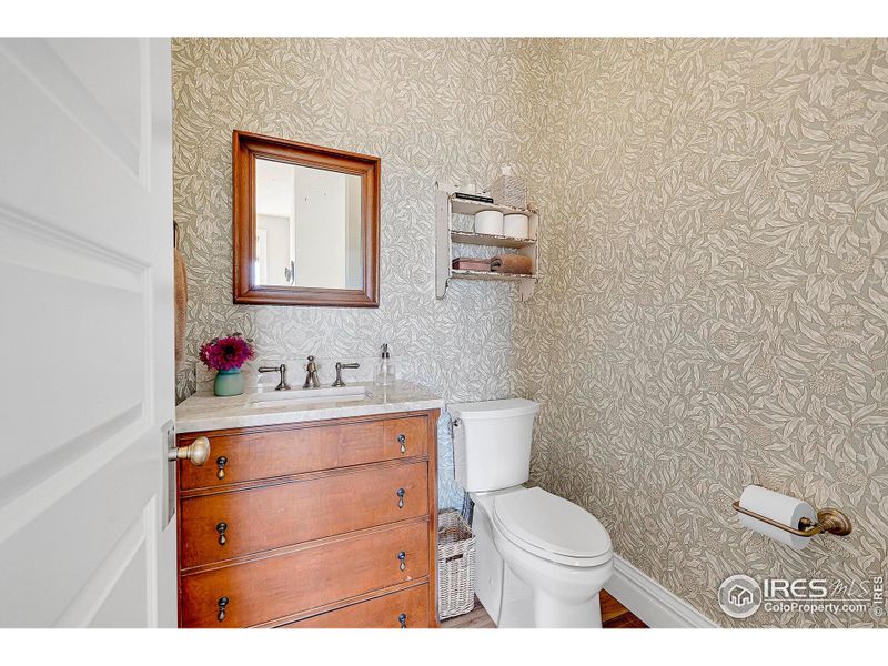 Gorgeous wallpaper and antique custom vanity in powder room