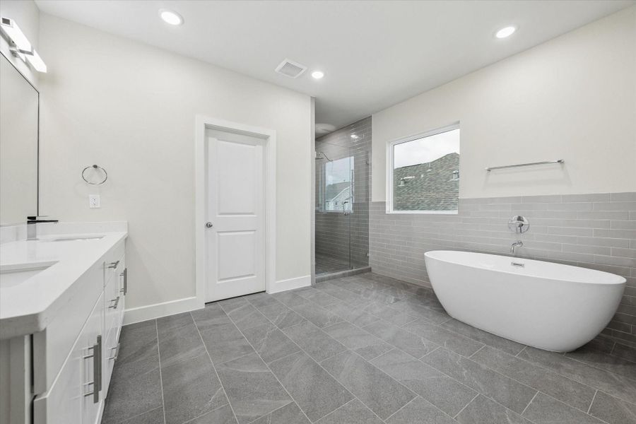 Primary bath, porcelain tiles, chrome finishes, large soaking sub, quartz counters, frameless glass shower.