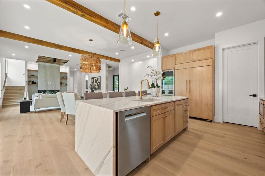 Rich wood floors and exposed ceiling beams bring organic warmth to this open culinary space.
