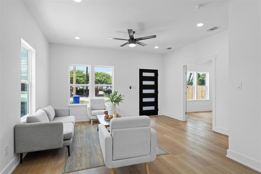 Living room with ceiling fan, light wood-style floors, and recessed lighting Living room with ceiling fan, light wood-style floors, and recessed lighting