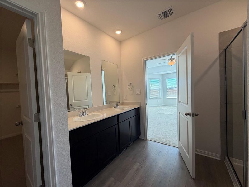 Full bathroom featuring double vanity, wood-style floors, recessed lighting, a stall shower, and ceiling fan