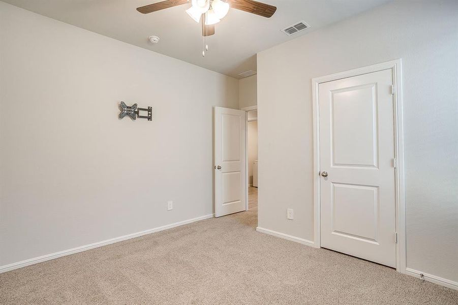 Unfurnished bedroom with carpet and a ceiling fan