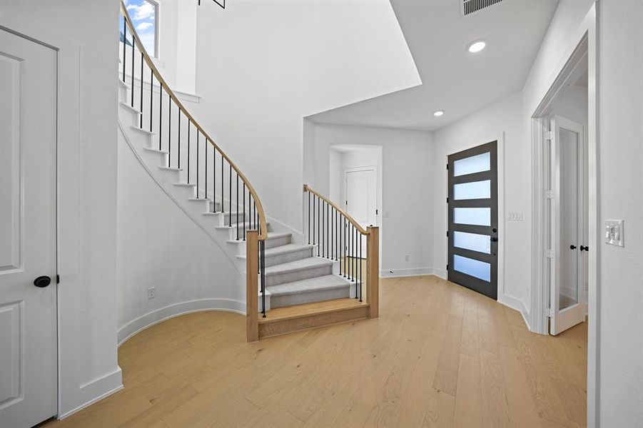 Entrance foyer with light wood-type flooring, stairs, and recessed lighting