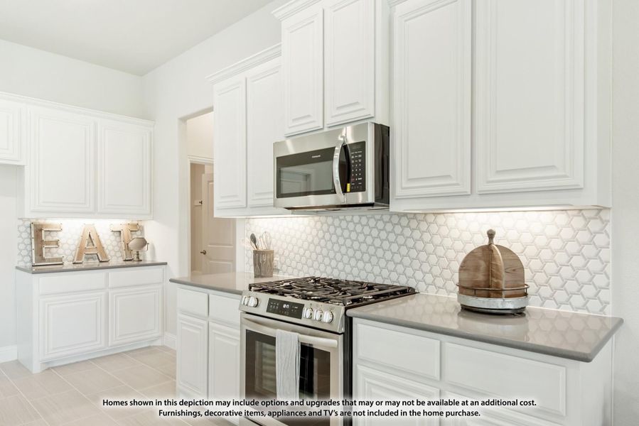 Kitchen with white cabinets, gray countertops, stainless steel gas range, and hexagon tile backsplash Kitchen with white cabinets, gray countertops, stainless steel gas range, and hexagon tile backsplash