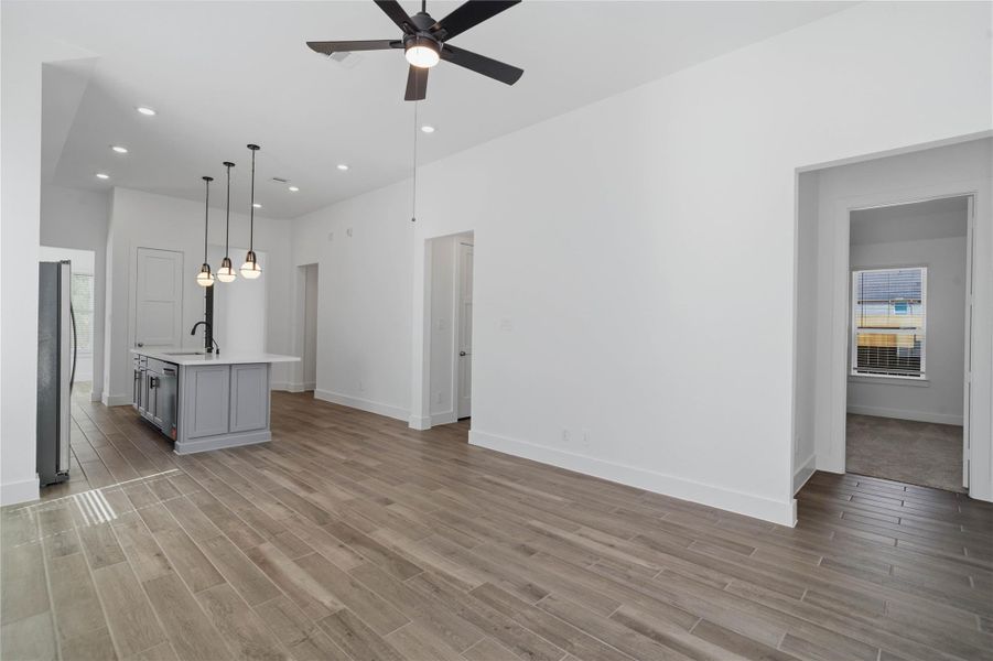 View from Family Room into the kitchen and hallway to primary suite as well as hallway to secondary bedrooms. View from Family Room into the kitchen and hallway to primary suite as well as hallway to secondary bedrooms.