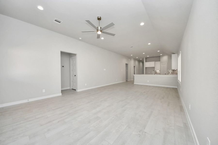 Welcome family and guests to your charming living room! With its high ceilings, recessed lighting, ceiling fan, custom paint, beautiful flooring, and large windows that let in abundant natural light, this room is perfect for gatherings. Sample photo of completed home with similar floor plan. Actual colors and selections may vary.