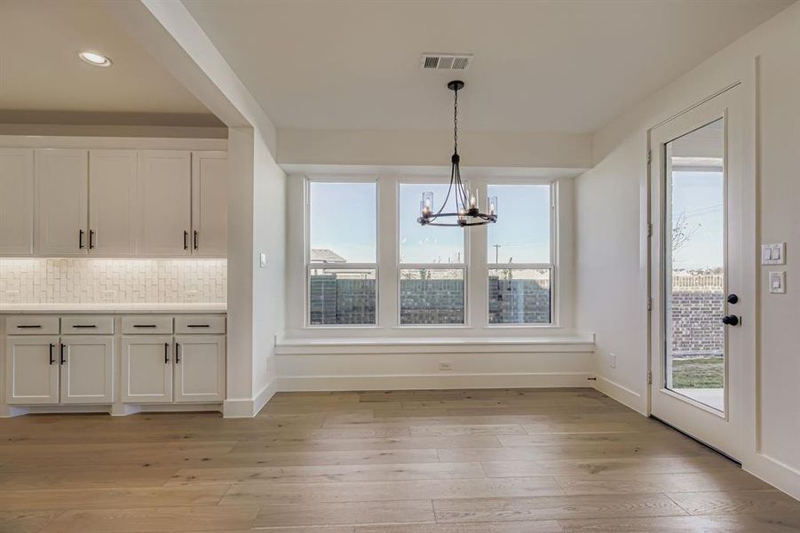 Unfurnished dining area with a chandelier, light wood-style flooring, and recessed lighting