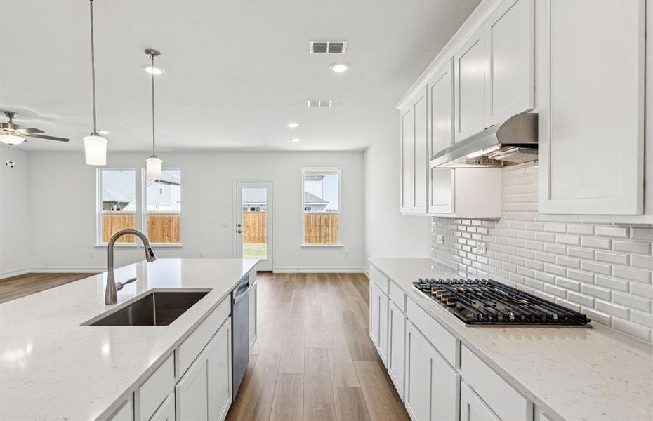 Open kitchen with adjoining nook featuring large windows and direct access to the backyard Open kitchen with adjoining nook featuring large windows and direct access to the backyard