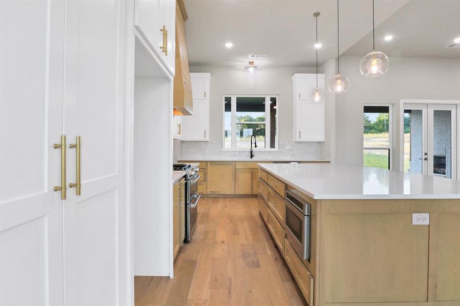 Kitchen with white cabinets, a kitchen island, appliances with stainless steel finishes, and a wealth of natural light