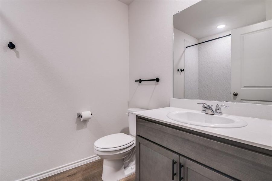Bathroom featuring vanity, dark wood finished floors, and a shower Bathroom featuring vanity, dark wood finished floors, and a shower