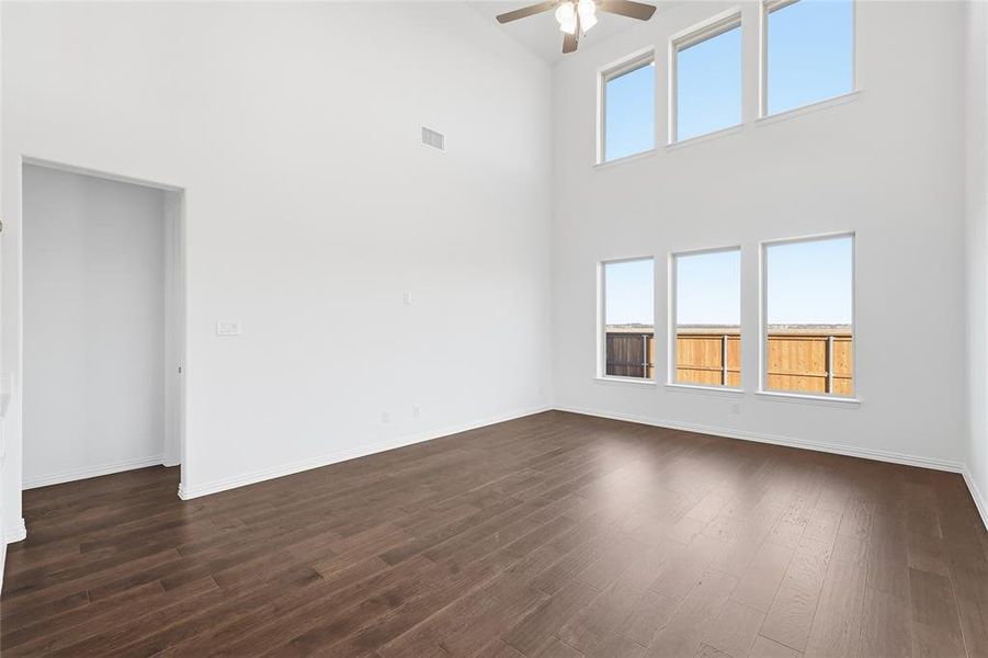 Expansive room featuring high ceilings, dark wood-finish flooring, and multiple large windows