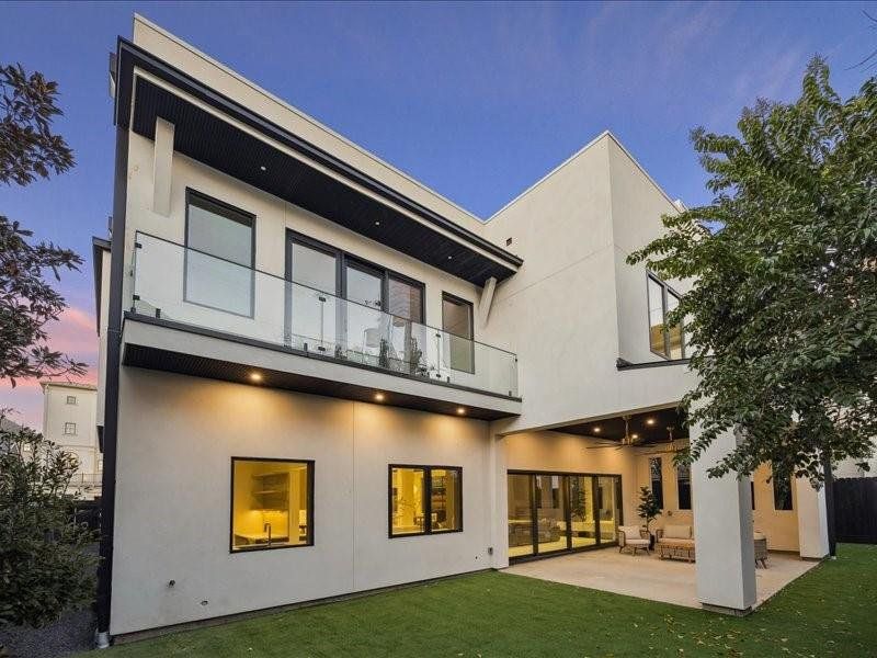 A view from the primary bedroom balcony offers a peaceful outlook surrounded by beautiful greenery and architectural elegance.