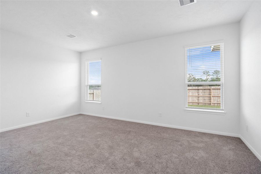 Relax and recharge in this stunning primary suite! This expansive room offers plush carpeting, neutral-toned walls, high ceilings, and large windows fitted with privacy blinds—perfect for unwinding after a long day.