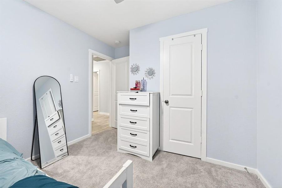 Carpeted room with light blue walls and a white paneled door