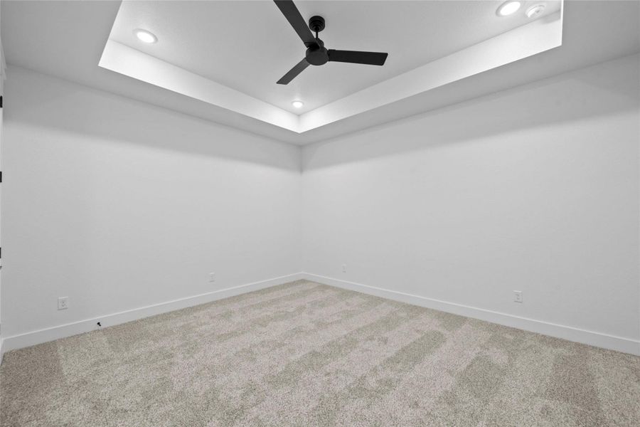 Empty room featuring a raised ceiling, light carpet, ceiling fan, and recessed lighting Empty room featuring a raised ceiling, light carpet, ceiling fan, and recessed lighting