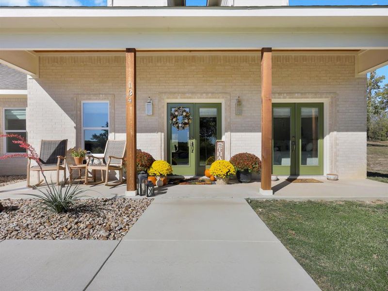 Doorway to property with covered porch and brick siding