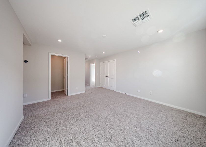 A long hallway with white doors.