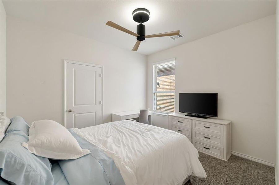 Bedroom featuring light colored carpet and a ceiling fan Bedroom featuring light colored carpet and a ceiling fan