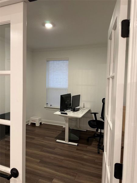Room with wood-finish flooring, white walls, and a recessed ceiling light Room with wood-finish flooring, white walls, and a recessed ceiling light