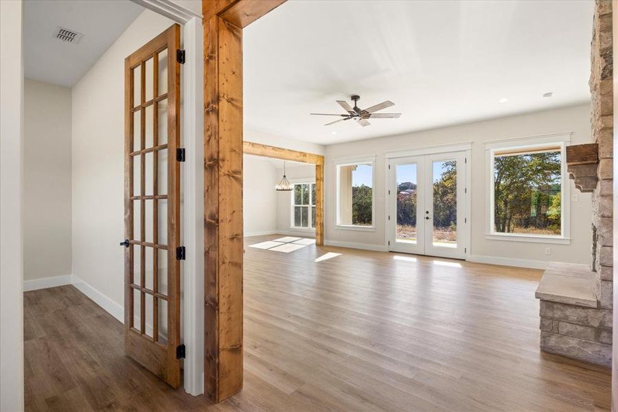 Unfurnished living room featuring french doors, light wood-style floors, and a ceiling fan