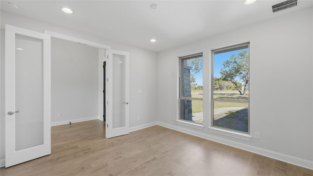 Unfurnished room featuring french doors, light wood-style flooring, and recessed lighting Unfurnished room featuring french doors, light wood-style flooring, and recessed lighting