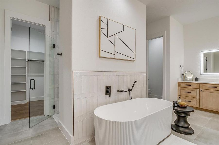 Full bathroom featuring vanity, independent shower and bath, toilet, and tile patterned flooring