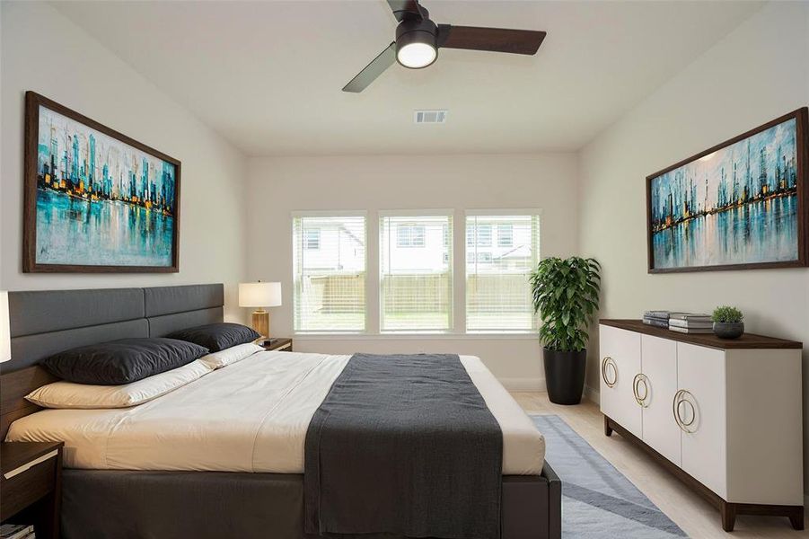 The spacious primary bedroom offers plush carpeting, a modern ceiling fan, and three large windows that flood the space with natural light, creating a warm and inviting atmosphere. The perfect retreat for relaxation, this room combines comfort and style, offering a blank canvas for your personal touch.