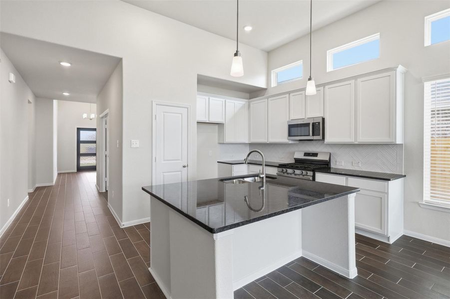 Stylish kitchen view showcasing granite countertops, tall white shaker cabinets, and a functional layout with plenty of prep space, all designed for both everyday living and entertaining. **Virtually Staged** Stylish kitchen view showcasing granite countertops, tall white shaker cabinets, and a functional layout with plenty of prep space, all designed for both everyday living and entertaining. **Virtually Staged**