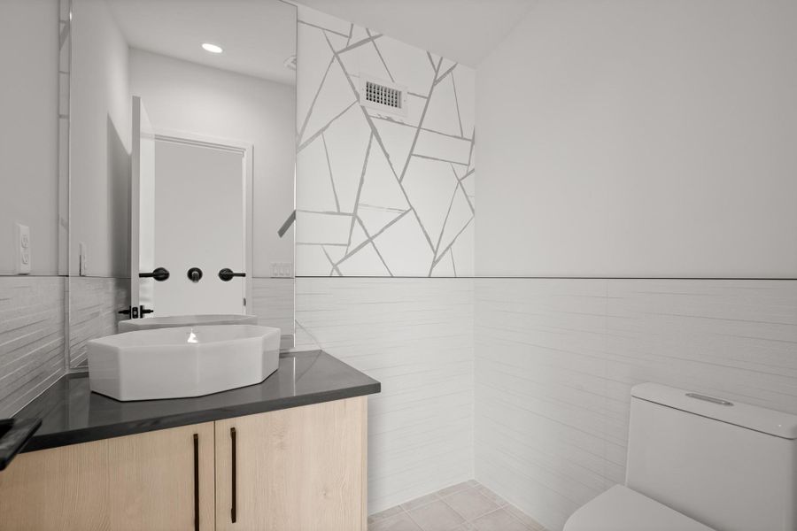 Half bath with tile walls and vanity