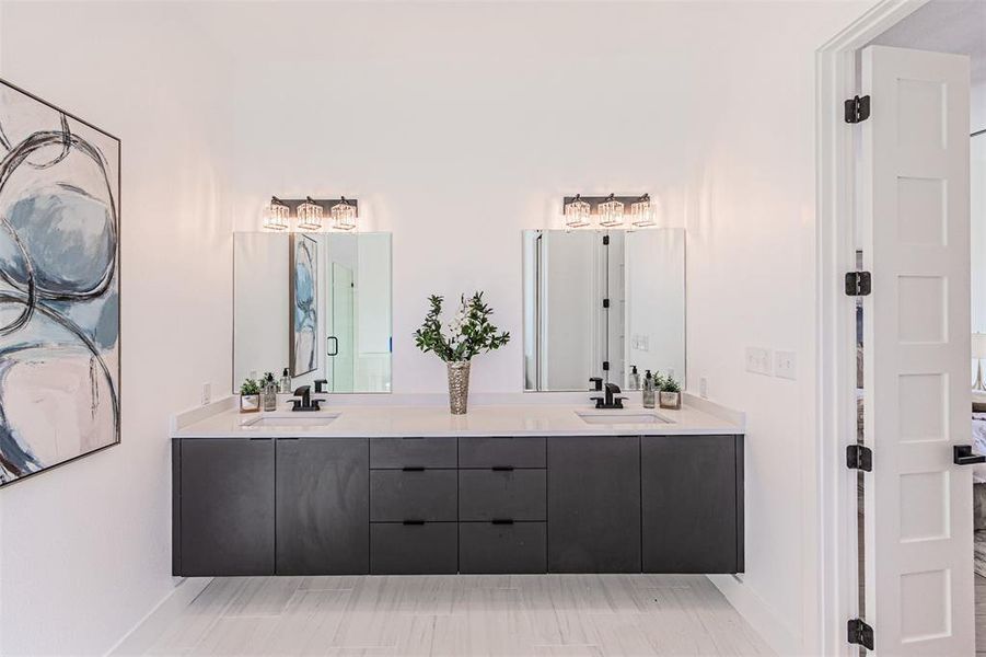 Bathroom featuring double vanity, light wood-style flooring, and a stall shower Bathroom featuring double vanity, light wood-style flooring, and a stall shower