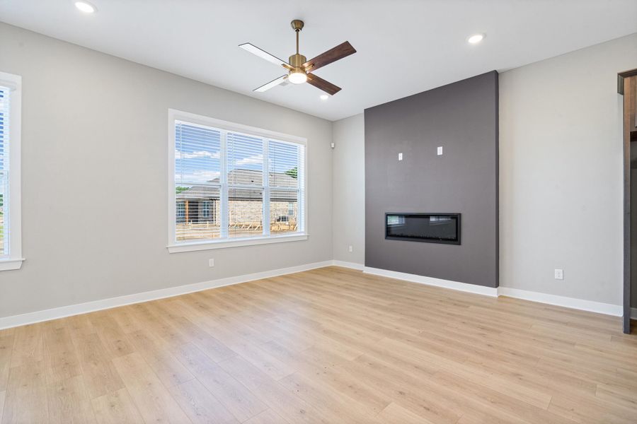 Modern living space featuring a built-in electric fireplace, recessed lighting, and a ceiling fan