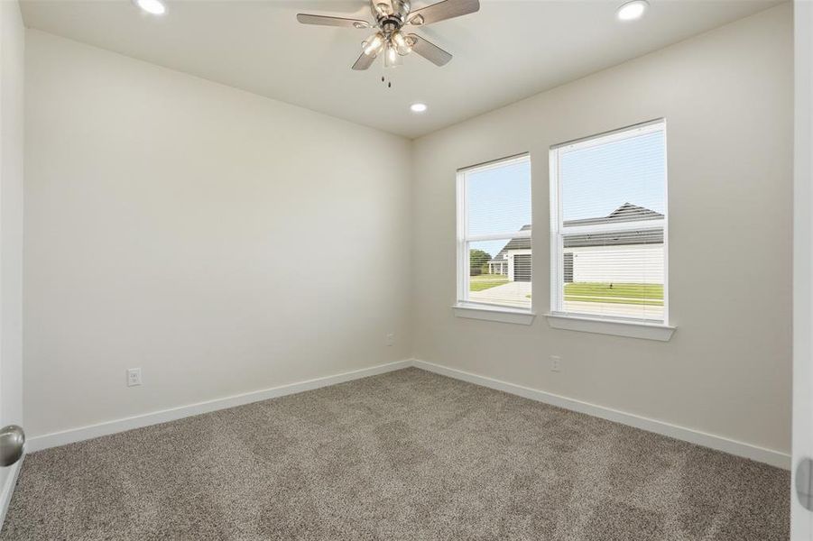 Carpeted room featuring dual windows, recessed lighting, a ceiling fan, and white baseboards
