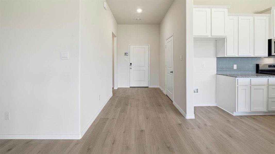 Hallway with light wood-style flooring and recessed lighting