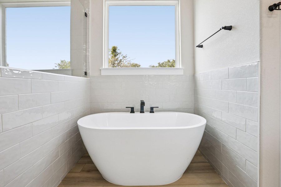 Full bath with a freestanding tub and tile walls