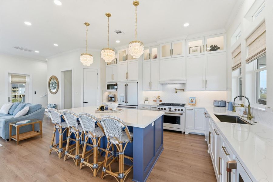 Soaring white custom cabinetry surrounds the elegant yet coastal Cafe appliances including a 36" Gas Stove. Burried propane tank is plumbed to both the kitchen and to the outdoor kitchen located on the ground level.