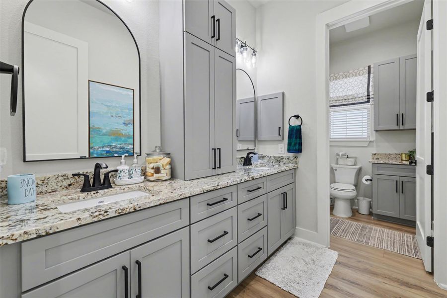 Full bathroom #3 featuring double vanity and light wood finished floors