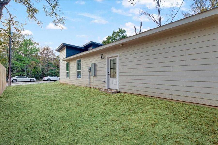 View of side of home featuring a yard