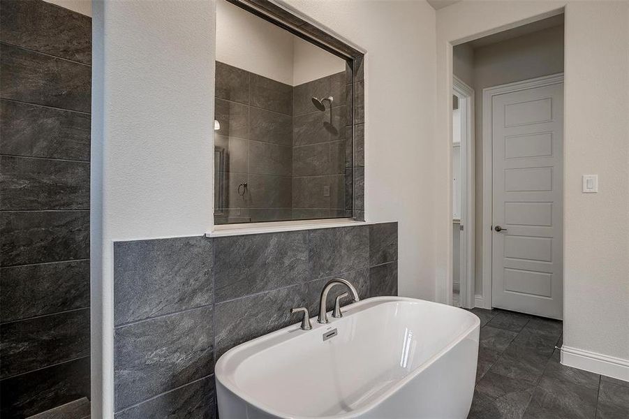 Bathroom featuring tile patterned flooring, tile walls, and plus walk in shower