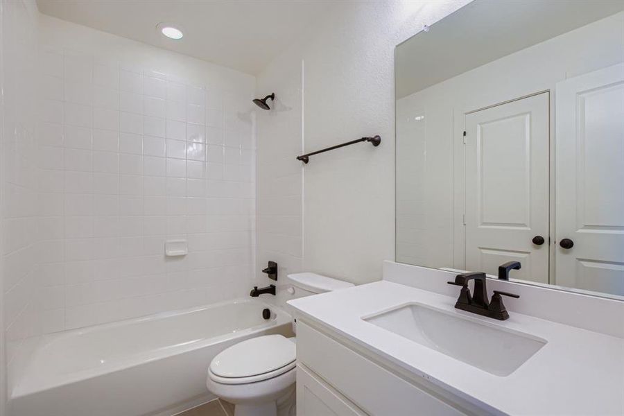 Bathroom with bathtub / shower combination, vanity, and recessed lighting