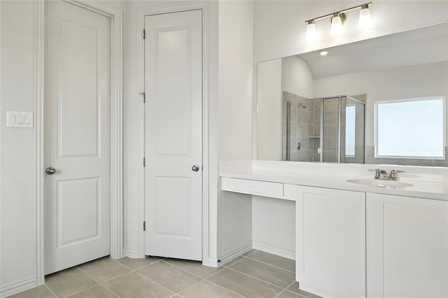 Full bath with a stall shower, light tile patterned floors, and vanity