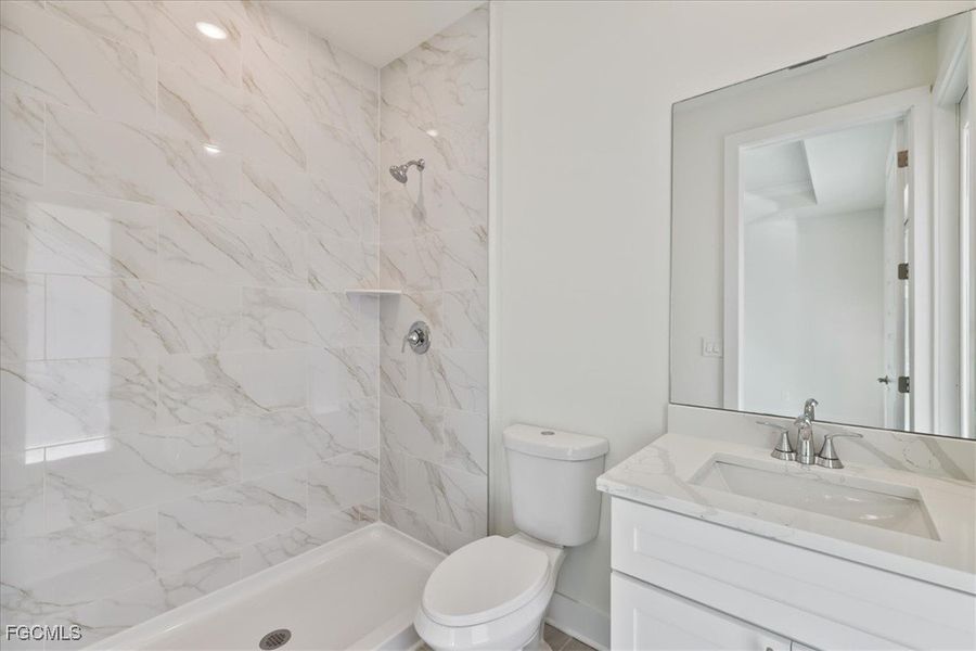 Bathroom with vanity and a marble finish shower Bathroom with vanity and a marble finish shower