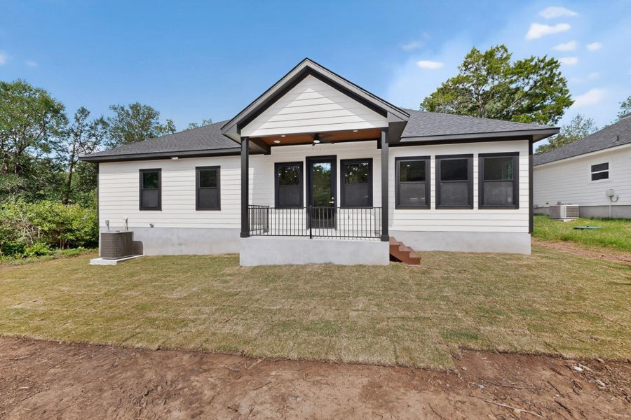 A striking modern farmhouse design with a covered back porch and freshly laid sod.