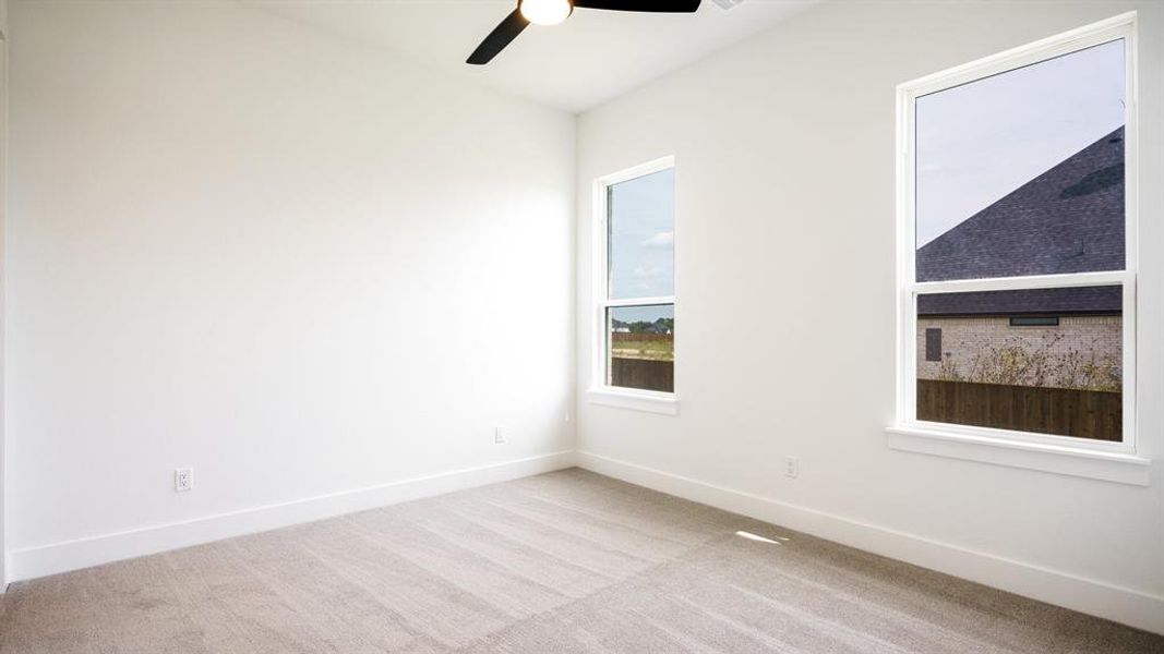 Spare room featuring light carpet and ceiling fan