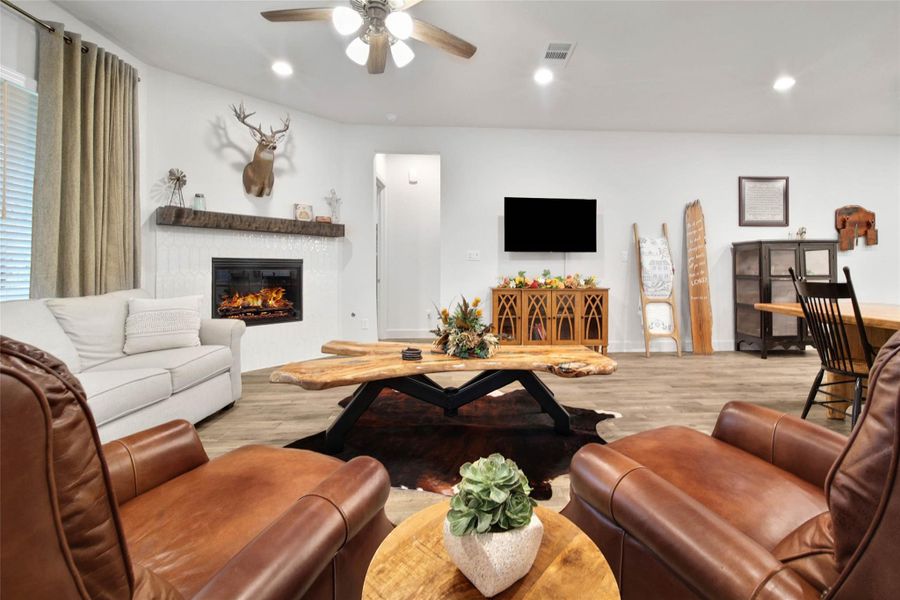 The family room is anchored by a corner gas-log fireplace with a tile surround & distinctive wood artisan mantle.