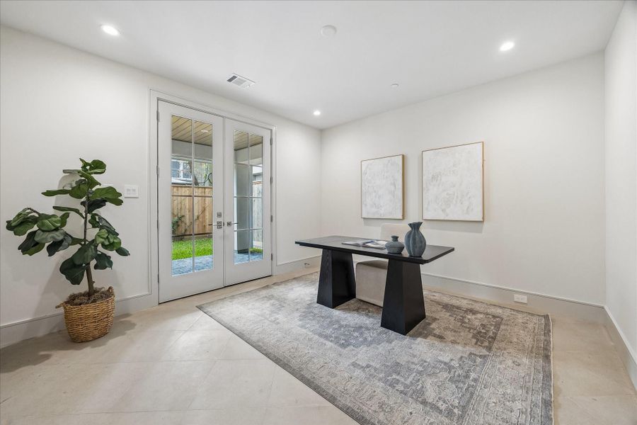 The first floor bedroom can be used as a bedroom, office, or gym. The French doors open to the Pavilion or backyard, which will be customized to the new home-owner's preference with pavers or artificial turf.