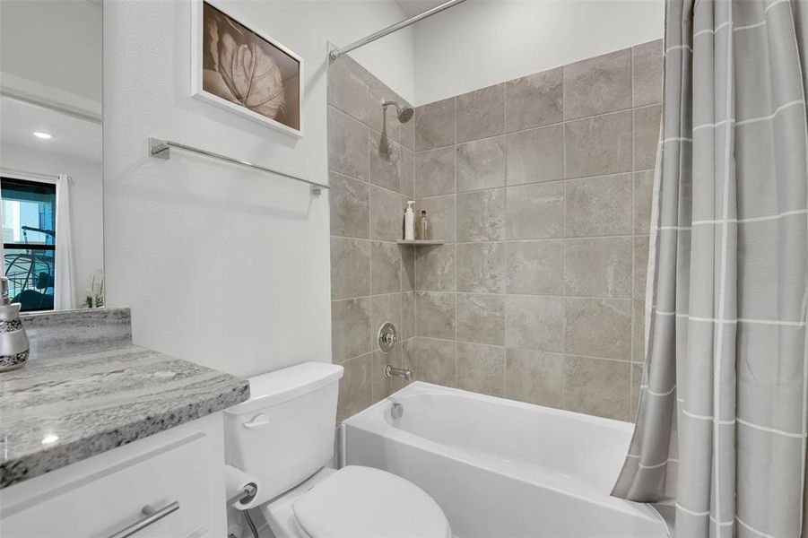 Full bathroom with shower / tub combo, vanity, and toilet