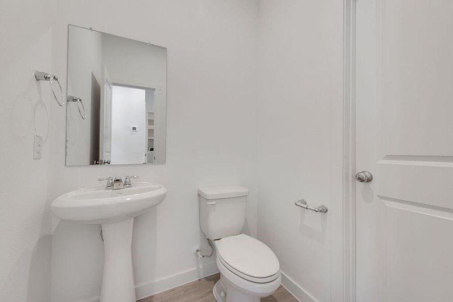 Bathroom featuring toilet and wood finished floors Bathroom featuring toilet and wood finished floors